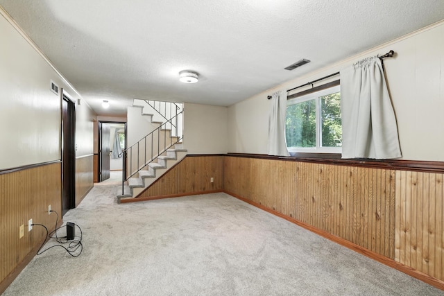 1958 6th St N, North Saint Paul, MN 55109 - basement featuring wooden walls, carpet floors, crown molding, a textured ceiling, and stairway