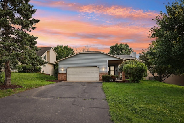 1318 Windcrest Ave, Eagan, MN 55123 - view of front of property with brick siding, an attached garage, asphalt driveway, and a yard