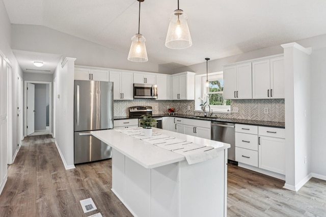 1318 Windcrest Ave, Eagan, MN 55123 - kitchen with stainless steel appliances, backsplash, light wood finished floors, a kitchen island, and vaulted ceiling
