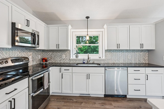 1318 Windcrest Ave, Eagan, MN 55123 - kitchen with stainless steel appliances, dark countertops, and white cabinetry