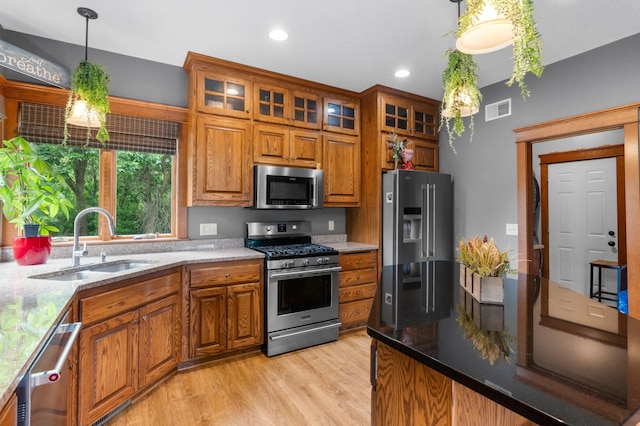 1222 81st Ct N, Brooklyn Park, MN 55444 - kitchen featuring appliances with stainless steel finishes, brown cabinetry, light wood finished floors, pendant lighting, and recessed lighting