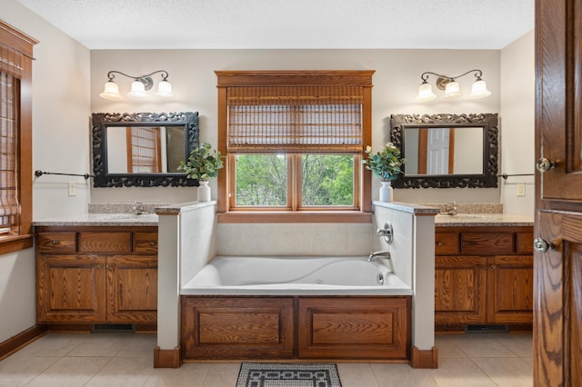 1222 81st Ct N, Brooklyn Park, MN 55444 - bathroom featuring a bath, tile patterned floors, two vanities, and a textured ceiling