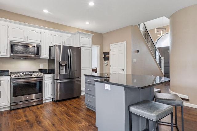 17964 Fresno St NW, Elk River, MN 55330 - kitchen featuring appliances with stainless steel finishes, dark countertops, a breakfast bar, and recessed lighting