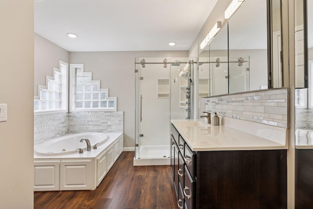 17964 Fresno St NW, Elk River, MN 55330 - full bath with a shower stall, wood finished floors, a jetted tub, decorative backsplash, and recessed lighting