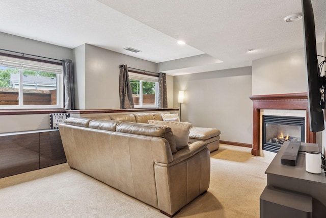 17964 Fresno St NW, Elk River, MN 55330 - living room with light carpet, a glass covered fireplace, healthy amount of natural light, a textured ceiling, and recessed lighting
