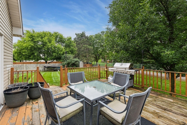 17964 Fresno St NW, Elk River, MN 55330 - wooden deck featuring outdoor dining area, area for grilling, a fenced backyard, view of scattered trees, and a shed