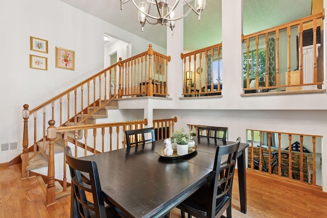 9743 Hemlock Ln N, Maple Grove, MN 55369 - dining room featuring wood finished floors, a chandelier, stairway, and a high ceiling