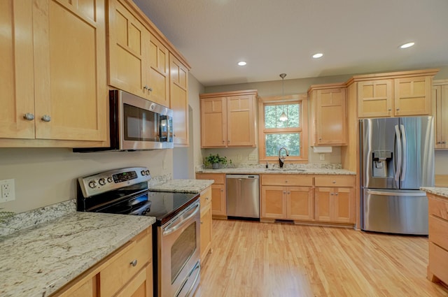 442 Wren Ln, Hudson, WI 54016 - kitchen with stainless steel appliances, light brown cabinets, light wood-type flooring, light stone counters, and recessed lighting