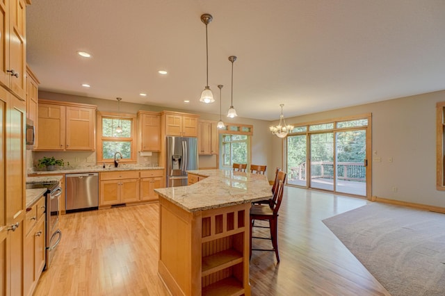 442 Wren Ln, Hudson, WI 54016 - kitchen with appliances with stainless steel finishes, light brown cabinetry, light wood-type flooring, a chandelier, and recessed lighting