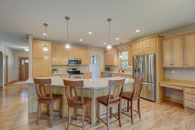 442 Wren Ln, Hudson, WI 54016 - kitchen featuring appliances with stainless steel finishes, light brown cabinets, light wood-style flooring, recessed lighting, and light stone counters