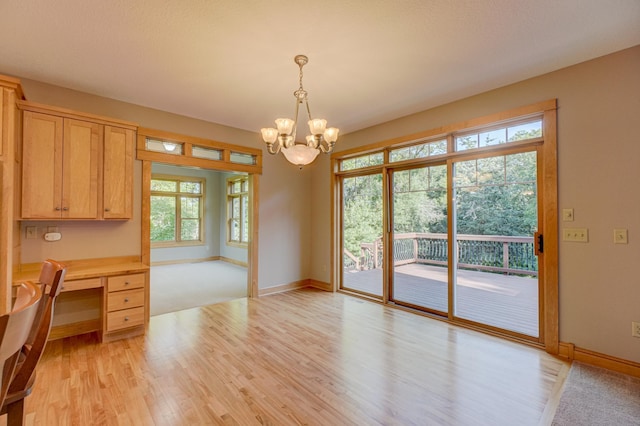 442 Wren Ln, Hudson, WI 54016 - unfurnished dining area with a chandelier, light wood-style flooring, and built in desk