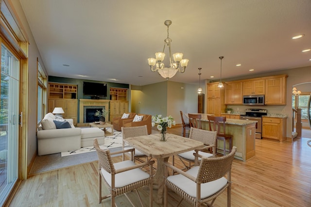 442 Wren Ln, Hudson, WI 54016 - dining space with a chandelier, light wood-type flooring, recessed lighting, and a fireplace