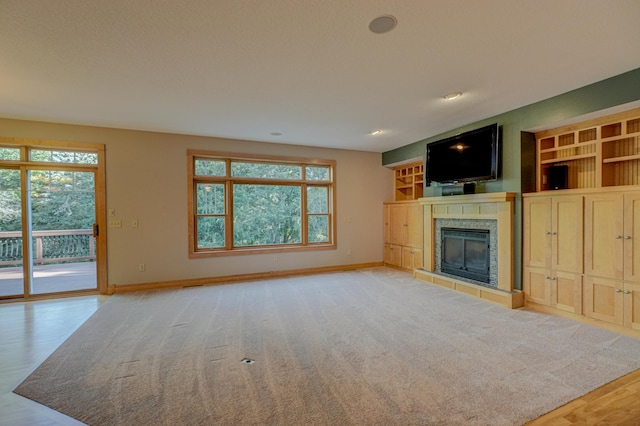 442 Wren Ln, Hudson, WI 54016 - unfurnished living room featuring a fireplace, healthy amount of natural light, light wood-style flooring, recessed lighting, and built in shelves