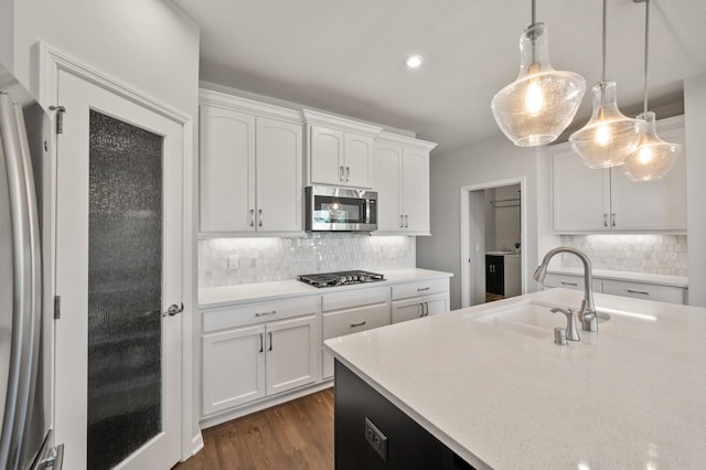 19400 75th Ave, Corcoran, MN 55340 - kitchen with appliances with stainless steel finishes, white cabinets, decorative backsplash, hanging light fixtures, and dark wood finished floors