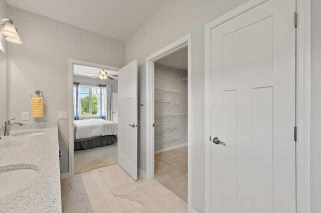 19400 75th Ave, Corcoran, MN 55340 - ensuite bathroom with double vanity, marble look tiles, a ceiling fan, and a spacious closet