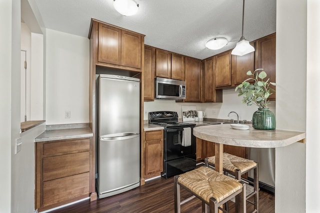3729 Snelling Ave Unit 108, Minneapolis, MN 55406 - kitchen with stainless steel appliances, dark wood-style floors, brown cabinetry, light countertops, and decorative light fixtures