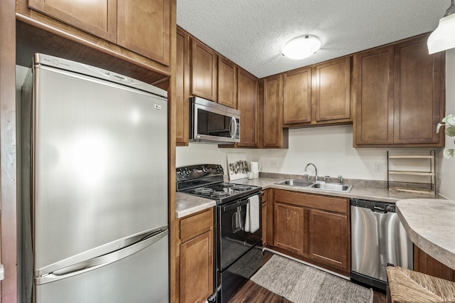 3729 Snelling Ave Unit 108, Minneapolis, MN 55406 - kitchen featuring stainless steel appliances, wood finished floors, light countertops, a textured ceiling, and brown cabinets