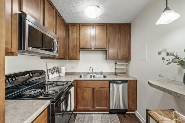 3729 Snelling Ave Unit 108, Minneapolis, MN 55406 - kitchen with appliances with stainless steel finishes, dark wood-type flooring, brown cabinetry, a textured ceiling, and light countertops