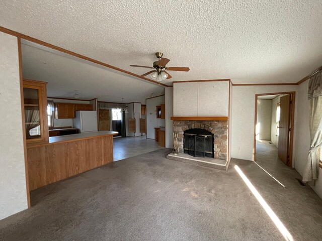 21344 County Road 11, Crosby, MN 56441 - unfurnished living room with a textured ceiling, a ceiling fan, a fireplace, ornamental molding, and carpet flooring
