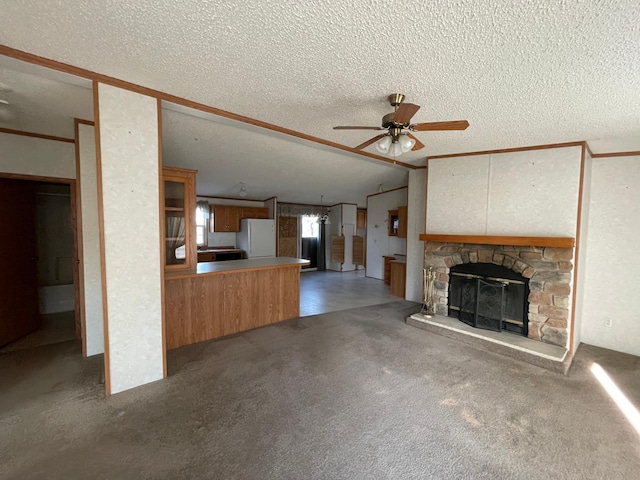 21344 County Road 11, Crosby, MN 56441 - unfurnished living room with a textured ceiling, ceiling fan, a stone fireplace, and carpet flooring