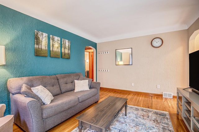 1821 Orange Ave E, Saint Paul, MN 55119 - living area featuring arched walkways, wood finished floors, and a textured wall