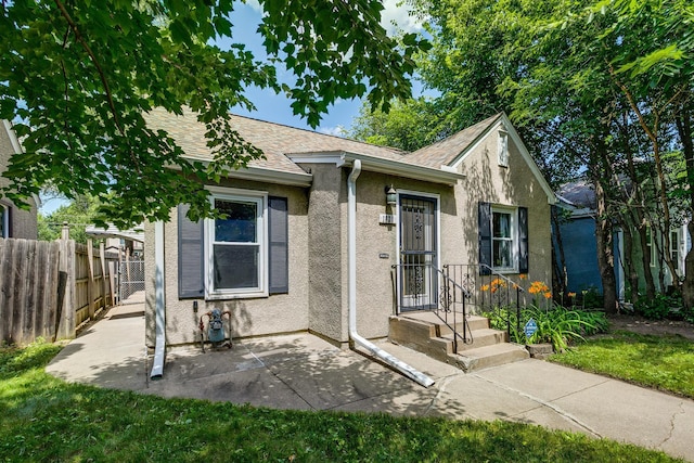 1821 Orange Ave E, Saint Paul, MN 55119 - view of front of property featuring stucco siding, roof with shingles, and a patio