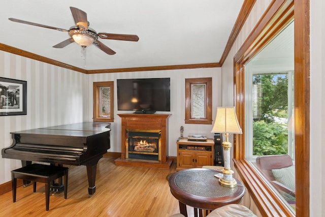 116 9th Ave NW, Rochester, MN 55901 - living area featuring light wood finished floors, crown molding, a glass covered fireplace, a ceiling fan, and wallpapered walls