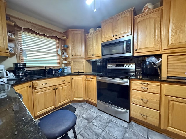 31044 Acorn Lake Rd, Frazee, MN 56544 - kitchen with stainless steel appliances, backsplash, dark stone countertops, and light brown cabinetry