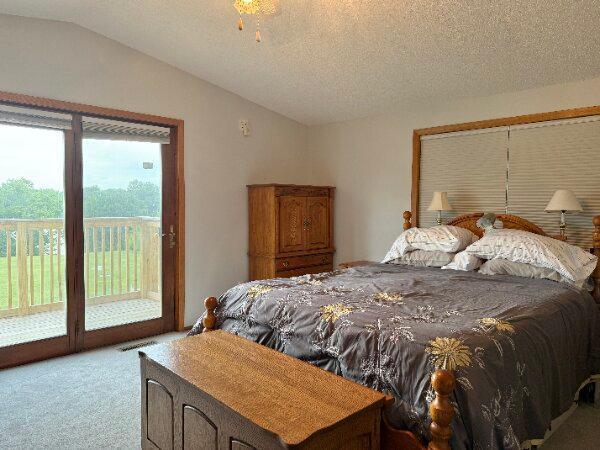31044 Acorn Lake Rd, Frazee, MN 56544 - carpeted bedroom with vaulted ceiling, access to exterior, and a textured ceiling