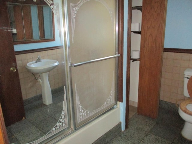 658 Bellows St, Saint Paul, MN 55107 - bathroom featuring tile walls, a stall shower, and wainscoting