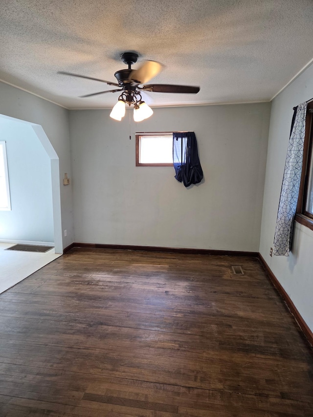 658 Bellows St, Saint Paul, MN 55107 - empty room with dark wood finished floors, a textured ceiling, a ceiling fan, and arched walkways