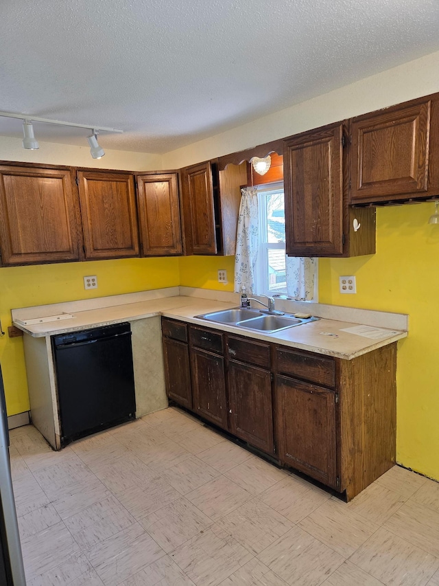 658 Bellows St, Saint Paul, MN 55107 - kitchen with black dishwasher, light countertops, track lighting, a textured ceiling, and light flooring