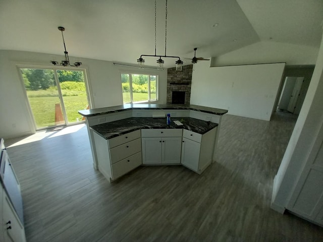 1267 146th Ave, New Richmond, WI 54017 - kitchen with open floor plan, a stone fireplace, lofted ceiling, wood finished floors, and white cabinetry