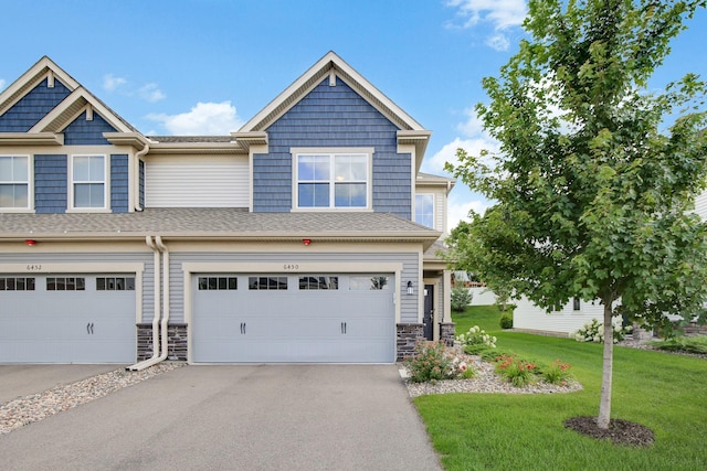 6450 Inspire Cir S, Cottage Grove, MN 55016 - craftsman-style house with a front lawn, an attached garage, asphalt driveway, and stone siding