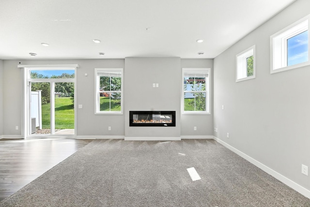 6450 Inspire Cir S, Cottage Grove, MN 55016 - unfurnished living room with recessed lighting, a glass covered fireplace, and carpet flooring