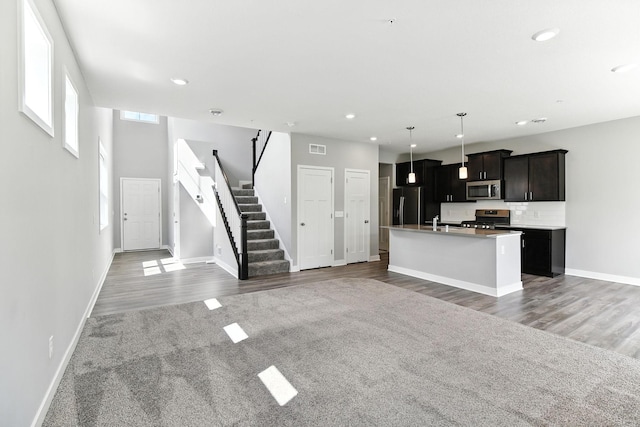 6450 Inspire Cir S, Cottage Grove, MN 55016 - kitchen with appliances with stainless steel finishes, open floor plan, an island with sink, recessed lighting, and wood finished floors