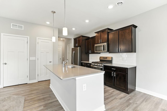 6450 Inspire Cir S, Cottage Grove, MN 55016 - kitchen with stainless steel appliances, a kitchen island with sink, light wood-type flooring, light countertops, and recessed lighting