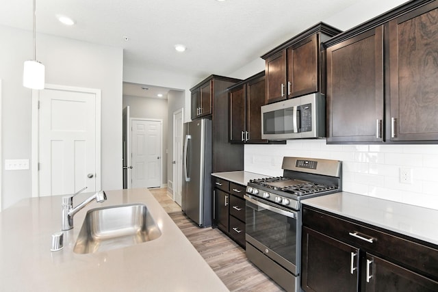 6450 Inspire Cir S, Cottage Grove, MN 55016 - kitchen with appliances with stainless steel finishes, light countertops, light wood-style flooring, backsplash, and dark brown cabinetry