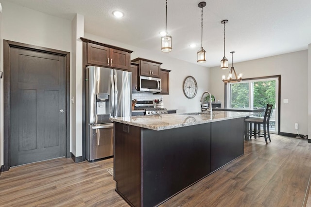 2065 Pleasant Dr, Prescott, WI 54021 - kitchen with stainless steel appliances, wood finished floors, tasteful backsplash, light stone counters, and recessed lighting