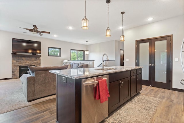 2065 Pleasant Dr, Prescott, WI 54021 - kitchen featuring dishwasher, light wood-type flooring, a center island with sink, light stone counters, and recessed lighting