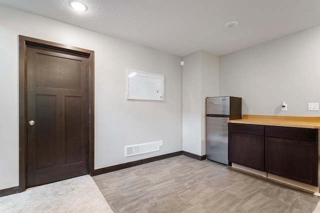 2065 Pleasant Dr, Prescott, WI 54021 - kitchen with freestanding refrigerator, light countertops, and dark brown cabinetry