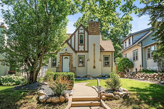 5321 Park Ave, Minneapolis, MN 55417 - english style home featuring a chimney, stucco siding, a front yard, and a shingled roof