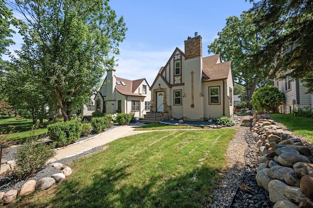 5321 Park Ave, Minneapolis, MN 55417 - rear view of property featuring stucco siding, a yard, a chimney, and a shingled roof