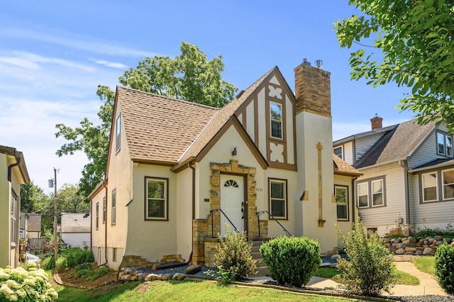5321 Park Ave, Minneapolis, MN 55417 - tudor-style house featuring stucco siding, a shingled roof, and a chimney