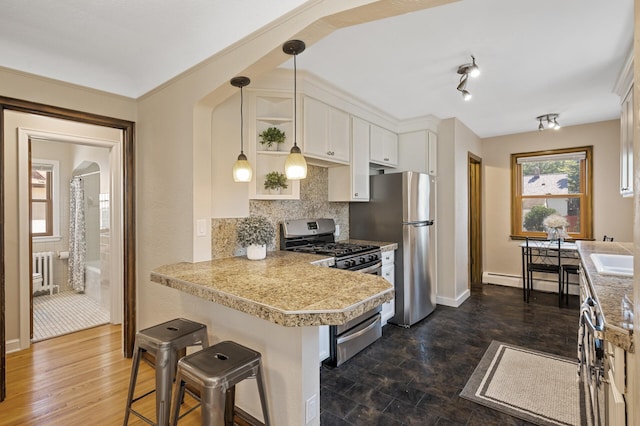 5321 Park Ave, Minneapolis, MN 55417 - kitchen with stainless steel appliances, a peninsula, a kitchen bar, white cabinets, and tasteful backsplash