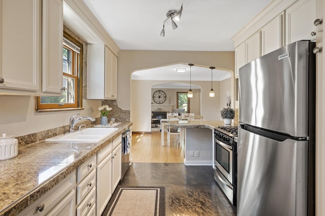 5321 Park Ave, Minneapolis, MN 55417 - kitchen featuring appliances with stainless steel finishes, arched walkways, decorative light fixtures, tile counters, and white cabinets