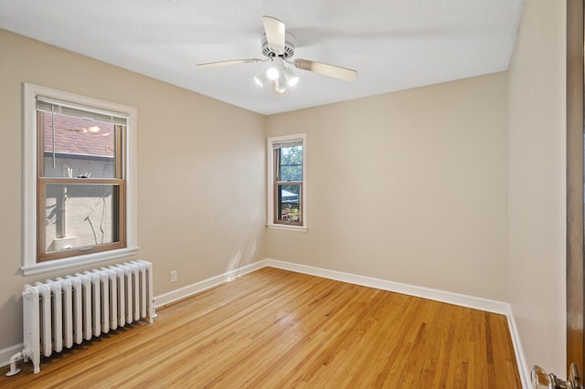 5321 Park Ave, Minneapolis, MN 55417 - unfurnished room with radiator heating unit, wood finished floors, and a ceiling fan
