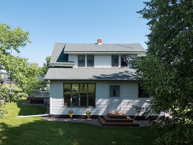 6770 County Road 65 NE, Deer River, MN 56636 - view of front of home featuring a chimney, a front lawn, roof with shingles, and a deck