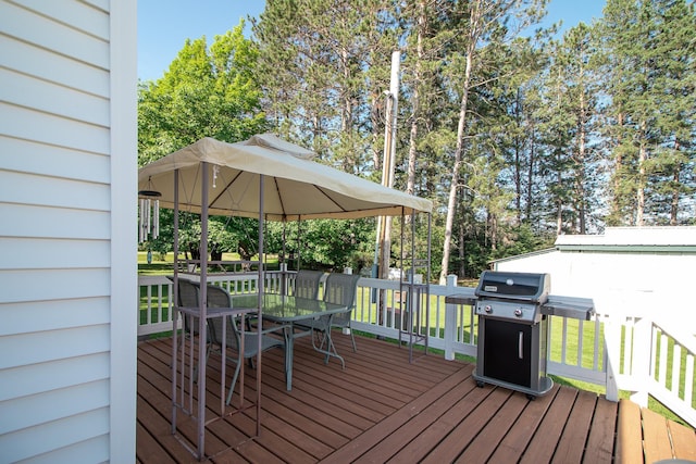6770 County Road 65 NE, Deer River, MN 56636 - wooden deck with outdoor dining space, area for grilling, a lawn, and view of wooded area