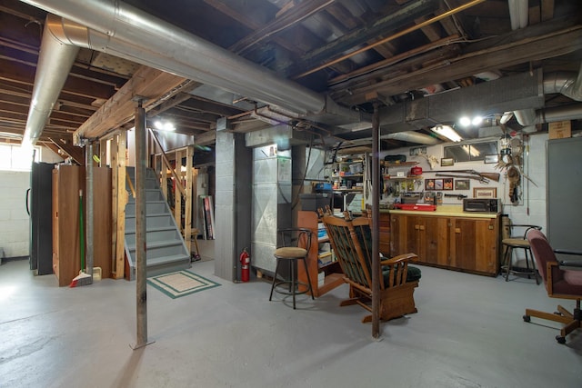 6770 County Road 65 NE, Deer River, MN 56636 - basement with stairway, freestanding refrigerator, and a workshop area